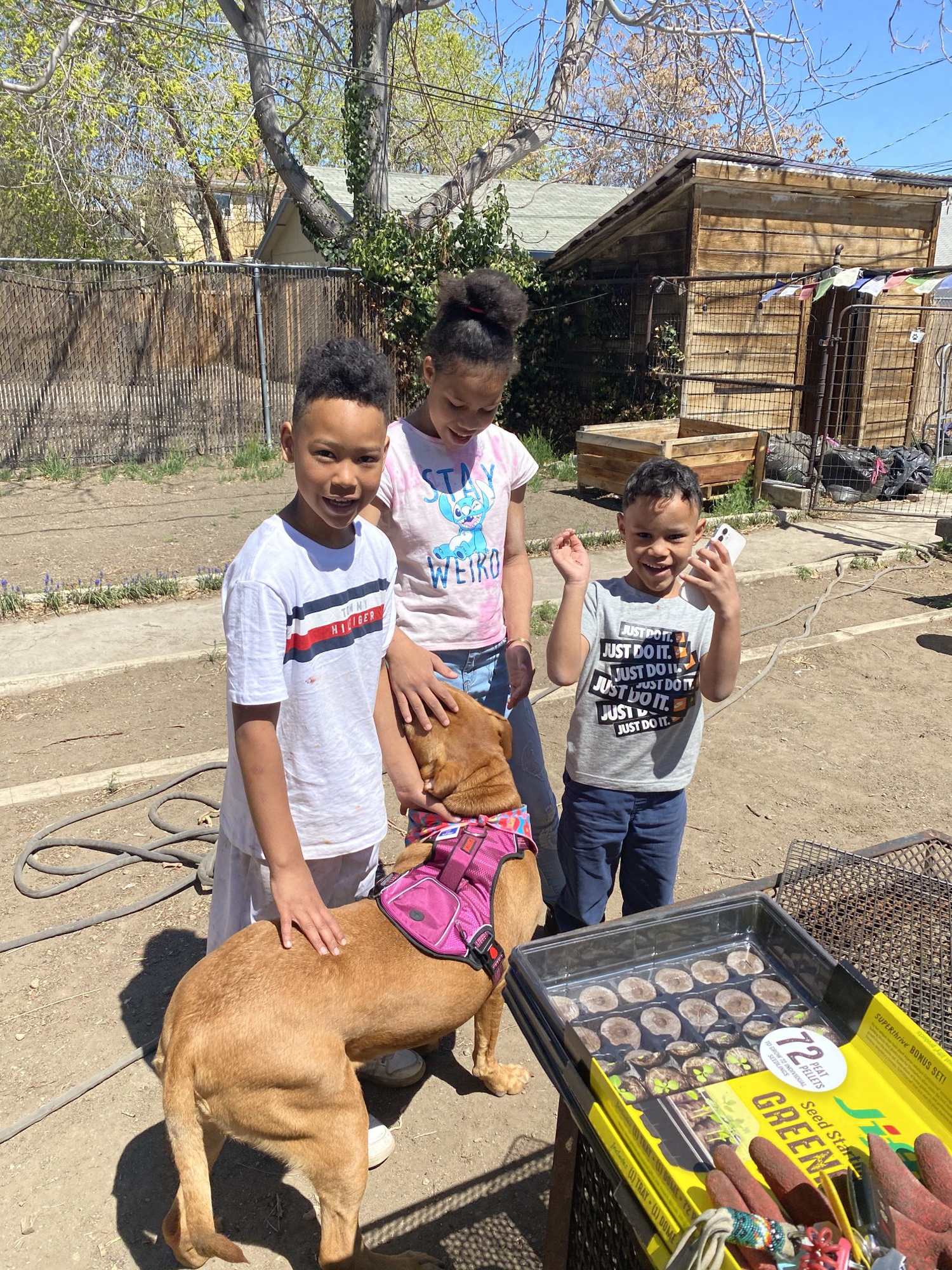 Kids petting a dog in a pink bandana